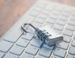 A combination lock rests on a computer keyboard.
