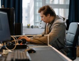 Free A concentrated professional working at a computer in a modern office setting. Stock Photo