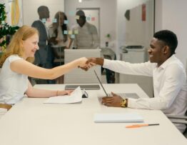 Free Business professionals completing a successful deal with a handshake in a modern office setting. Stock Photo