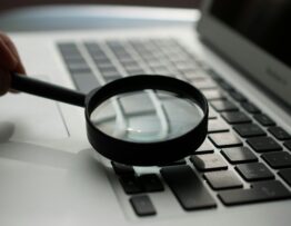 magnifying glass near gray laptop computer
