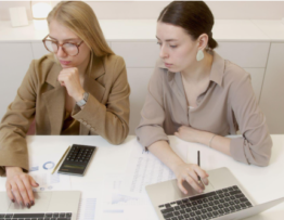 two women with laptops